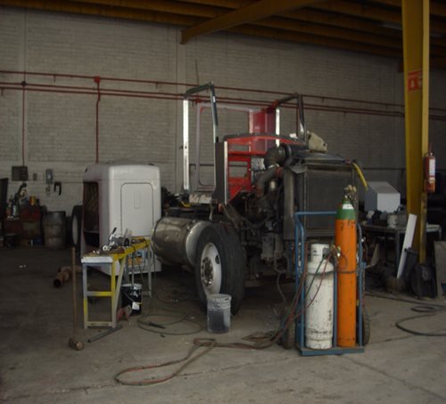 Espacio interior del taller con vehículos en reparación